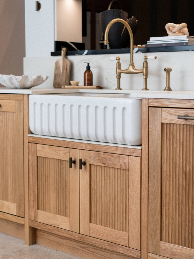 Traditional kitchen with a white Shaws fireclay sink and brass Perrin & Rowe tap, set in oak cabinetry with marble worktop